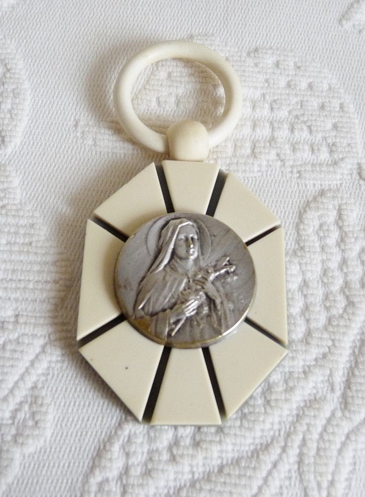 SOLD Antique Bakelite Cot Pendant, Saint Therese Of The Roses, Signed Karo, Atelier St Joseph  Circa 1930